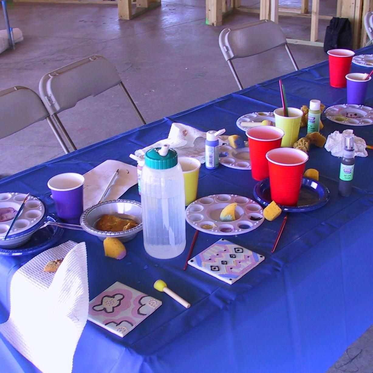 A table with plates and cups on it and a blue table cloth