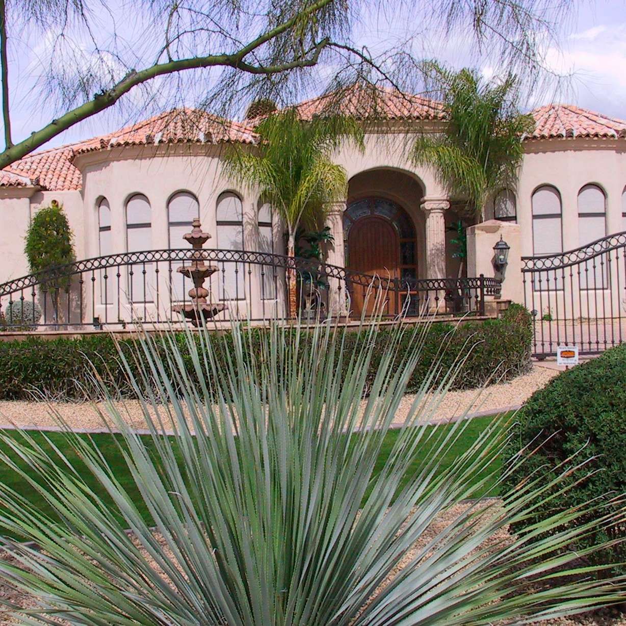 A large house with a fountain in front of it