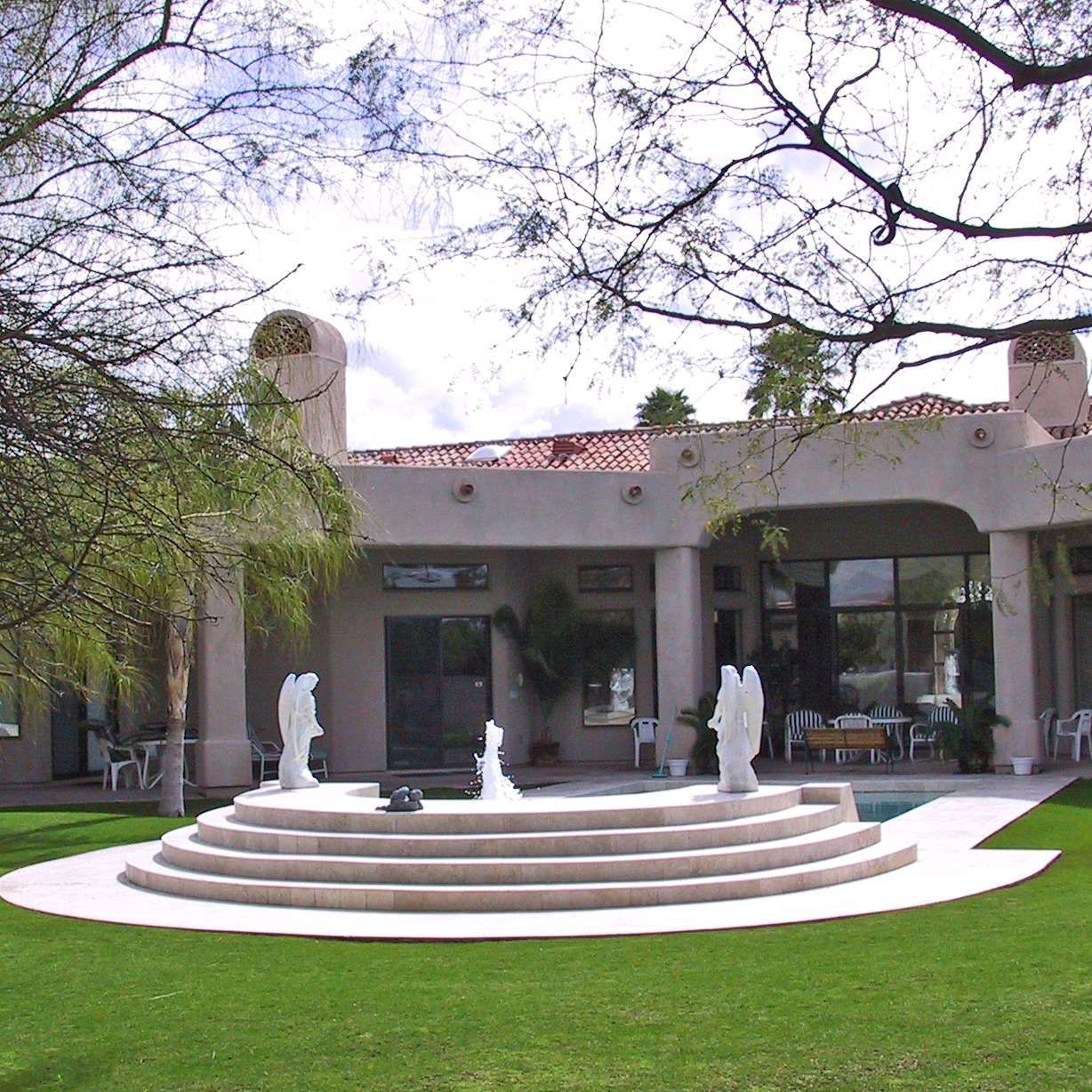 A large house with a fountain in front of it