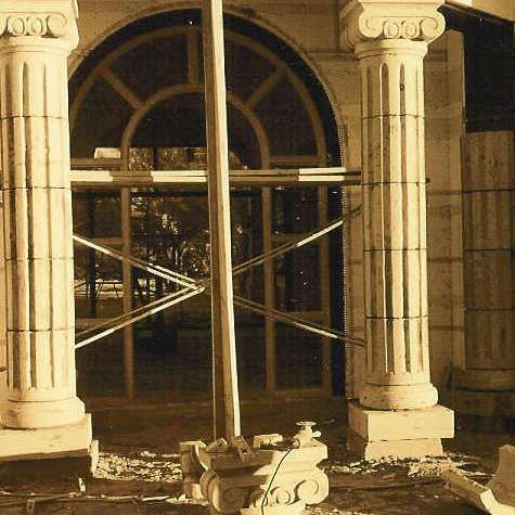 A black and white photo of a building with columns and a window