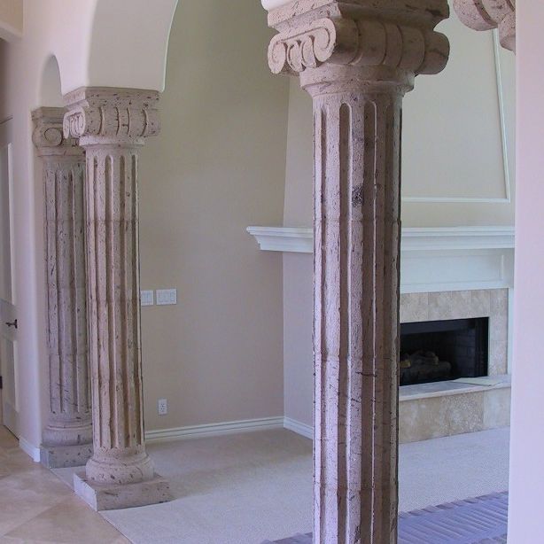 A living room with columns and a fireplace