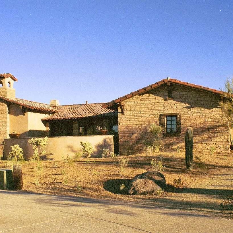 A large stone house with a red tile roof