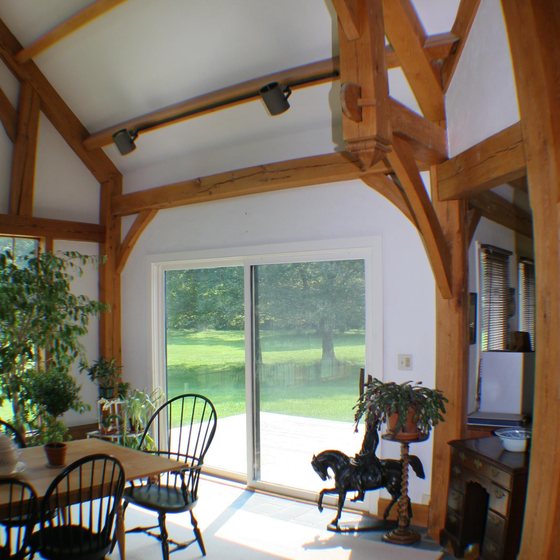 A room with a table and chairs and a horse on a stand