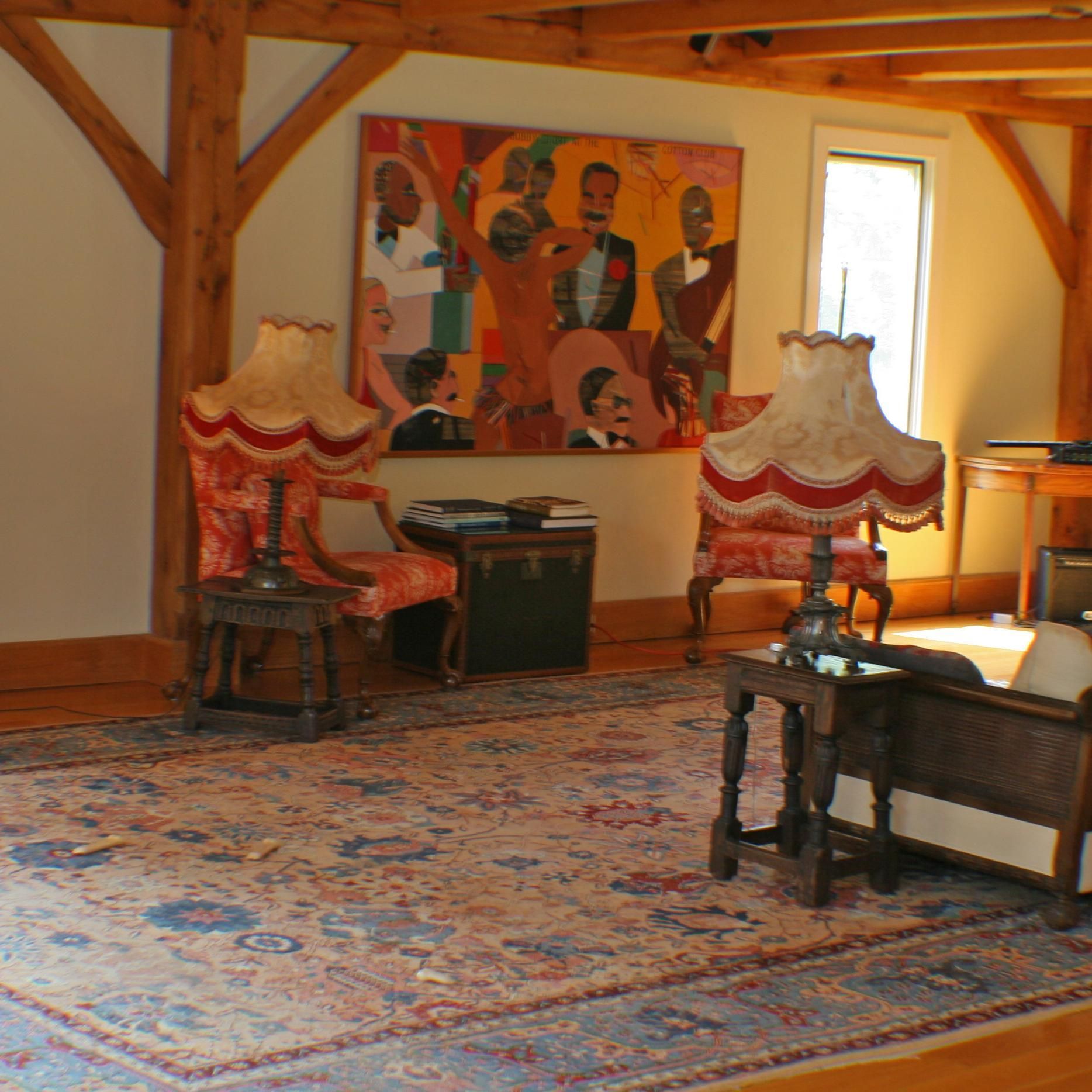 A living room with furniture and a painting on the wall