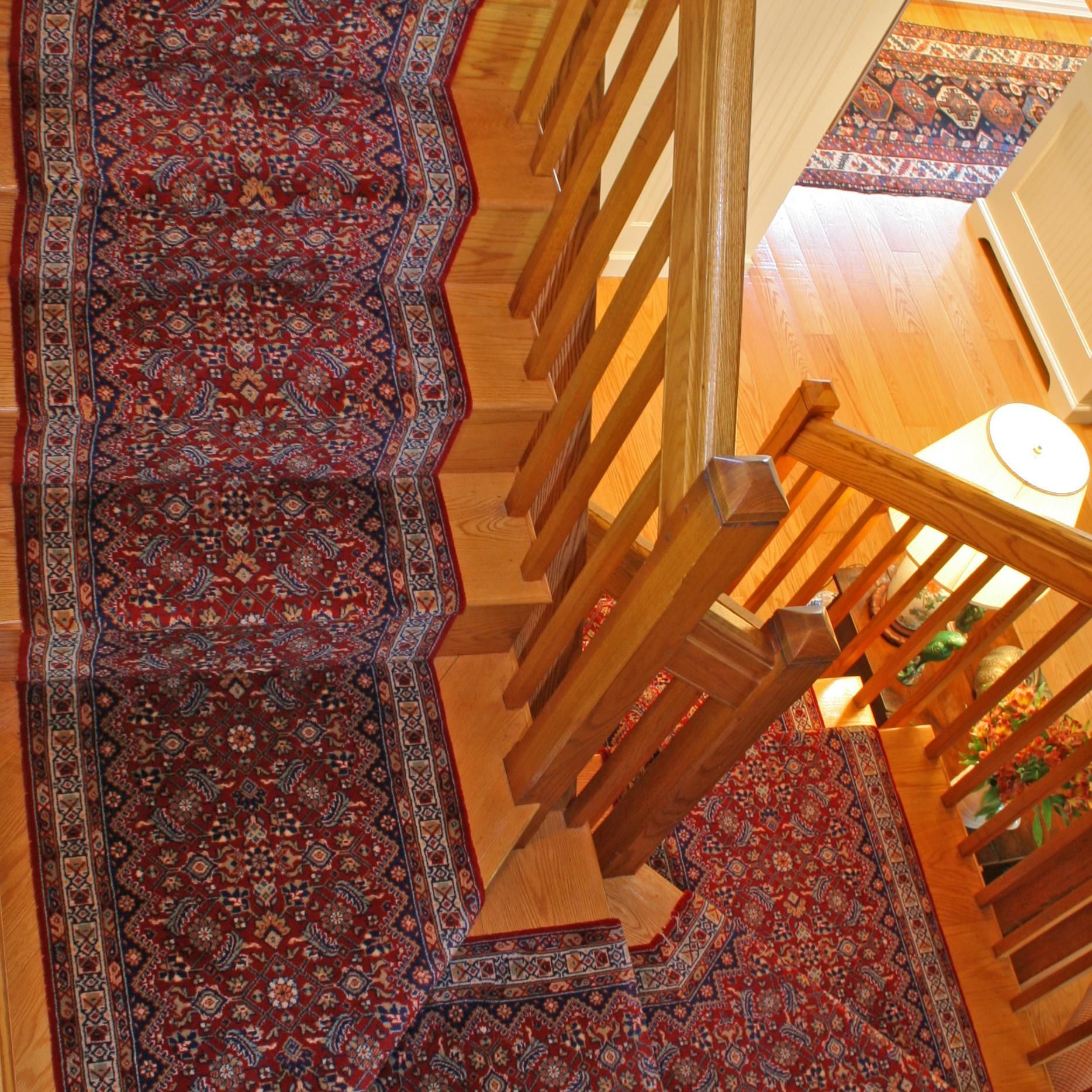A wooden staircase with a rug on the steps