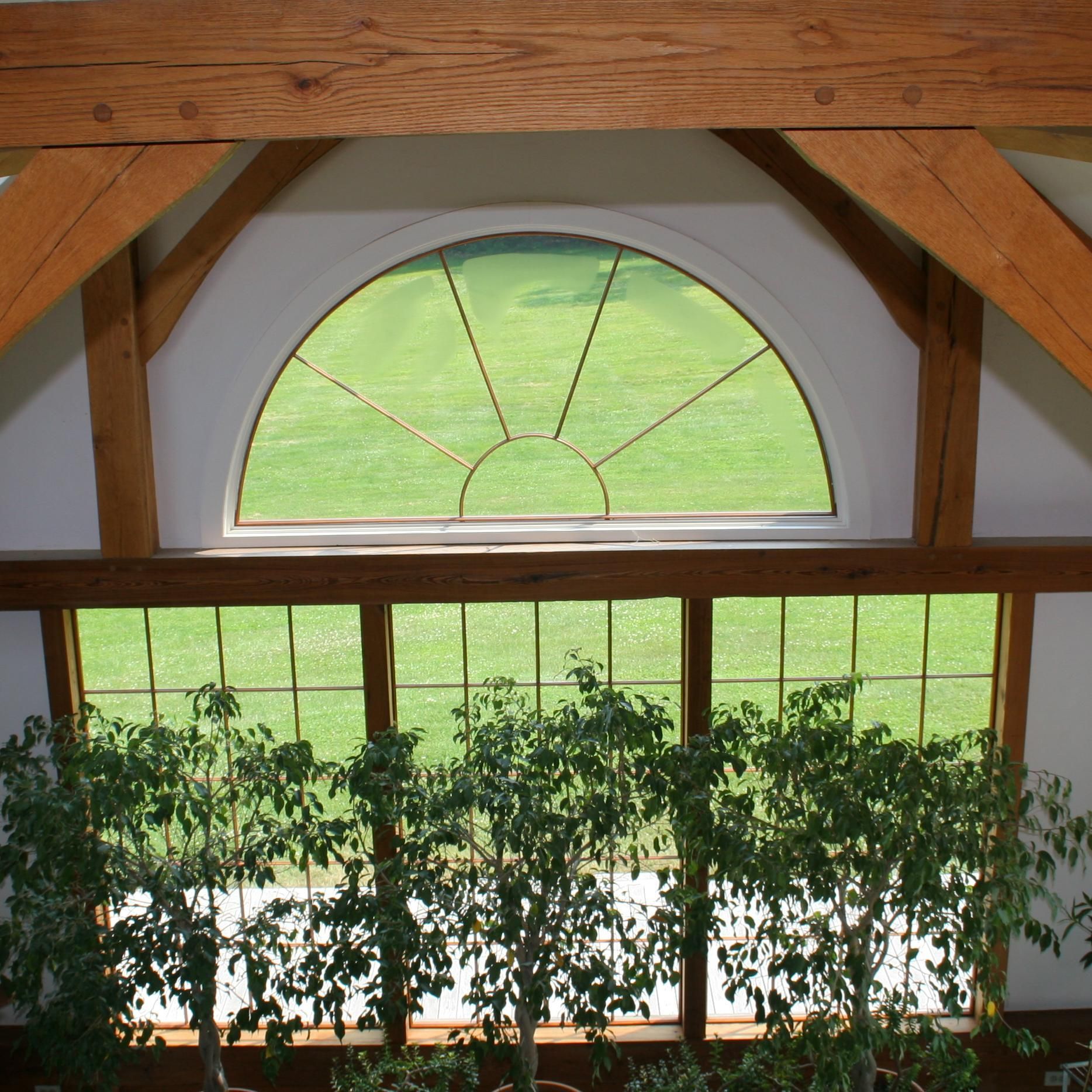 A large window with a view of a lush green field