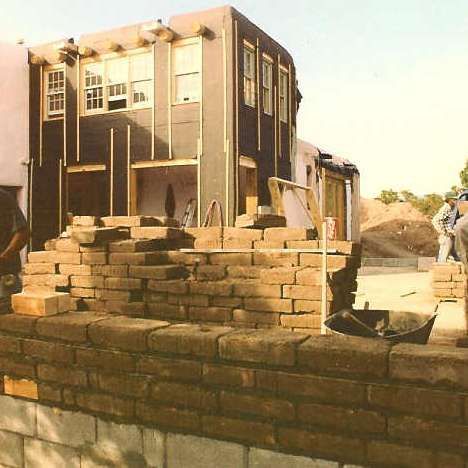 A brick wall is being built in front of a building