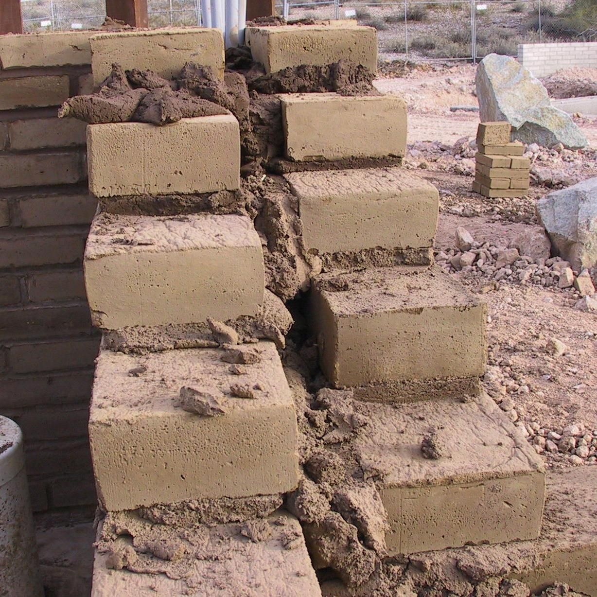 A brick wall is being built with clay bricks