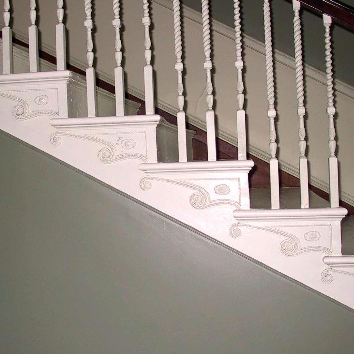 A close up of a white staircase with a railing