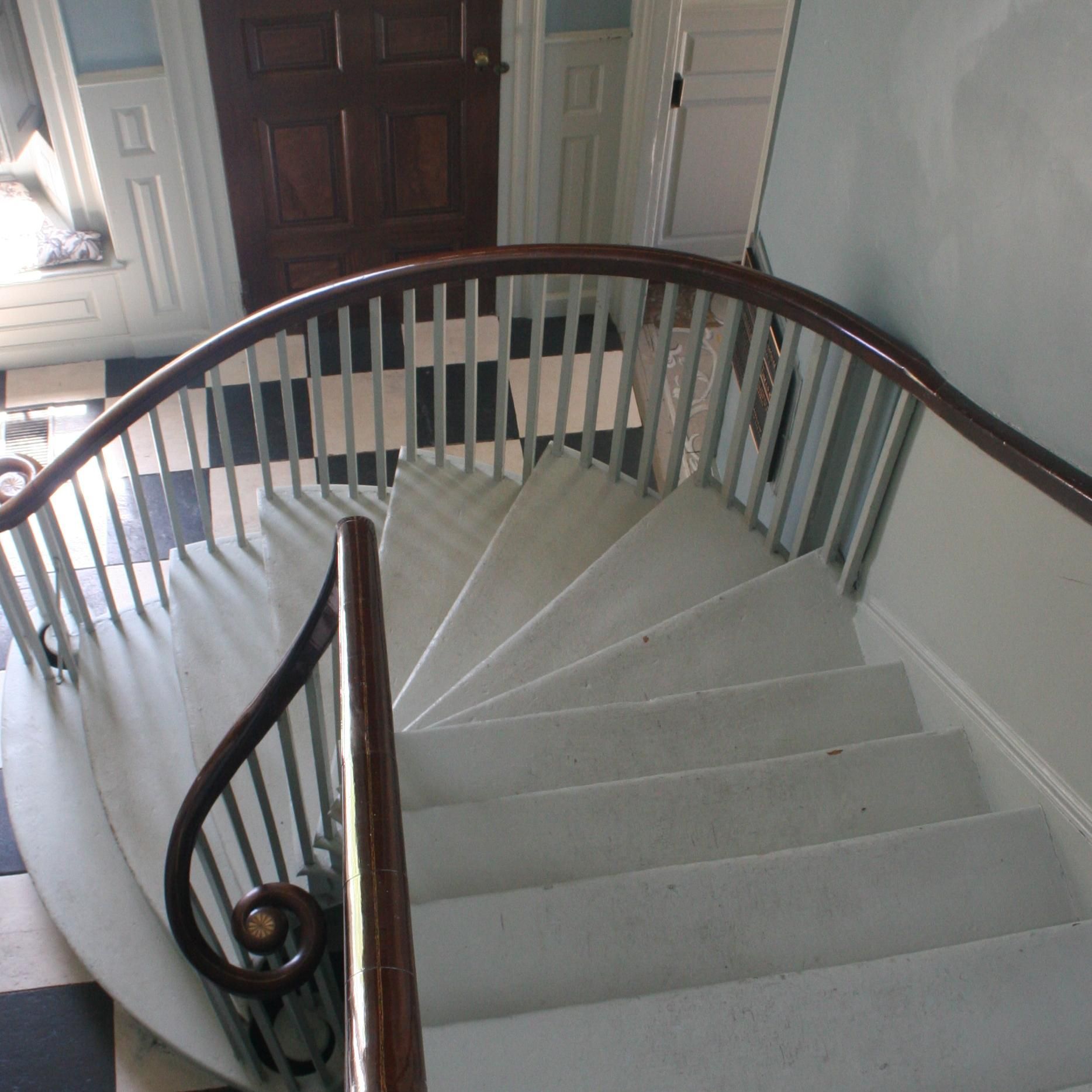 A spiral staircase with a wooden railing in a house