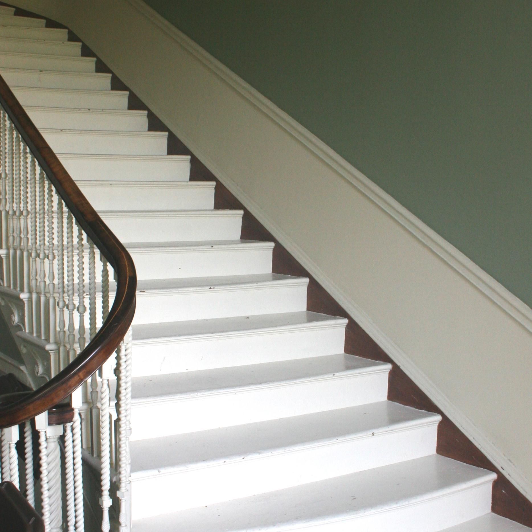 A staircase with white steps and a wooden railing
