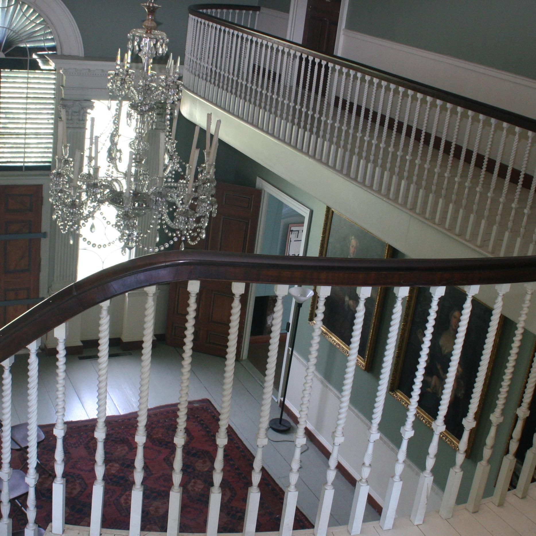 A staircase with a chandelier hanging from the ceiling