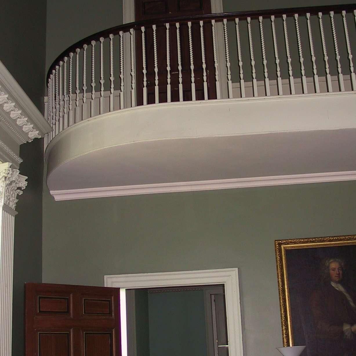 A room with a balcony and a painting on the wall