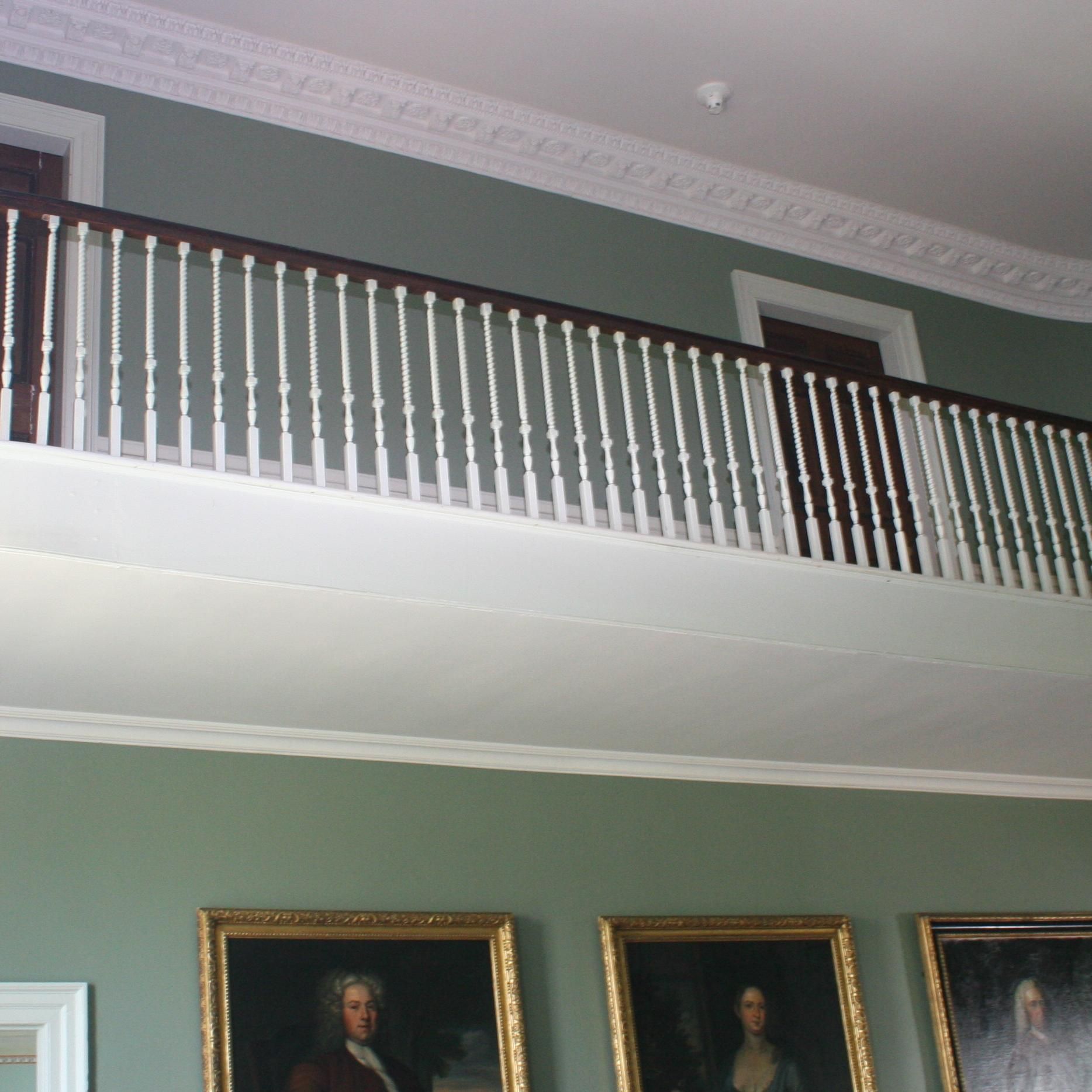 A room with a balcony and paintings on the wall