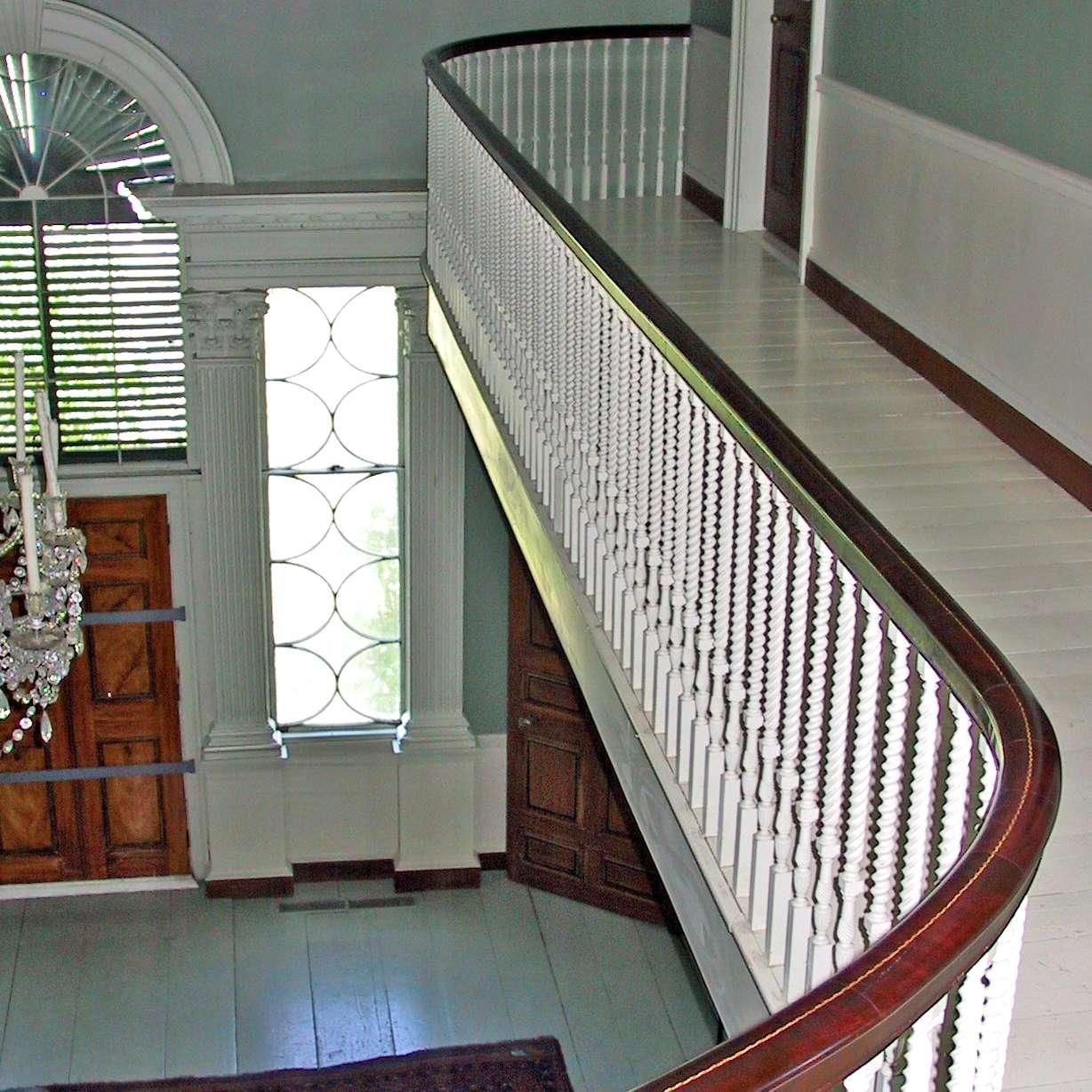 A staircase with a white railing and a chandelier hanging from the ceiling