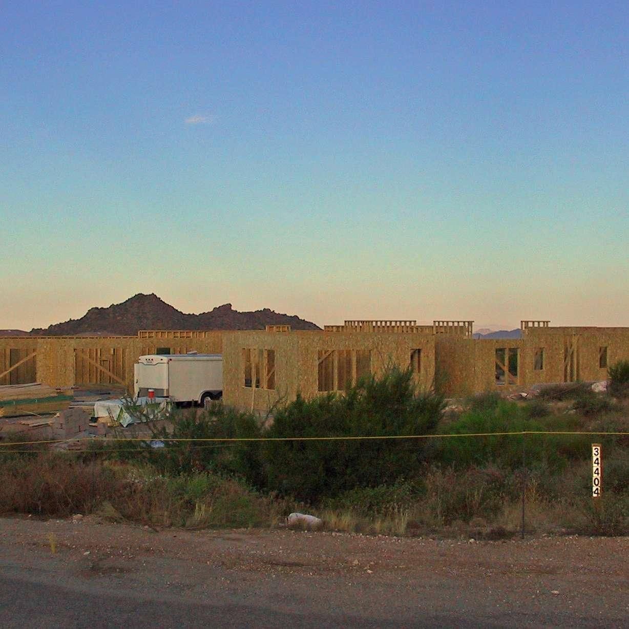 A white truck is parked in front of a building under construction