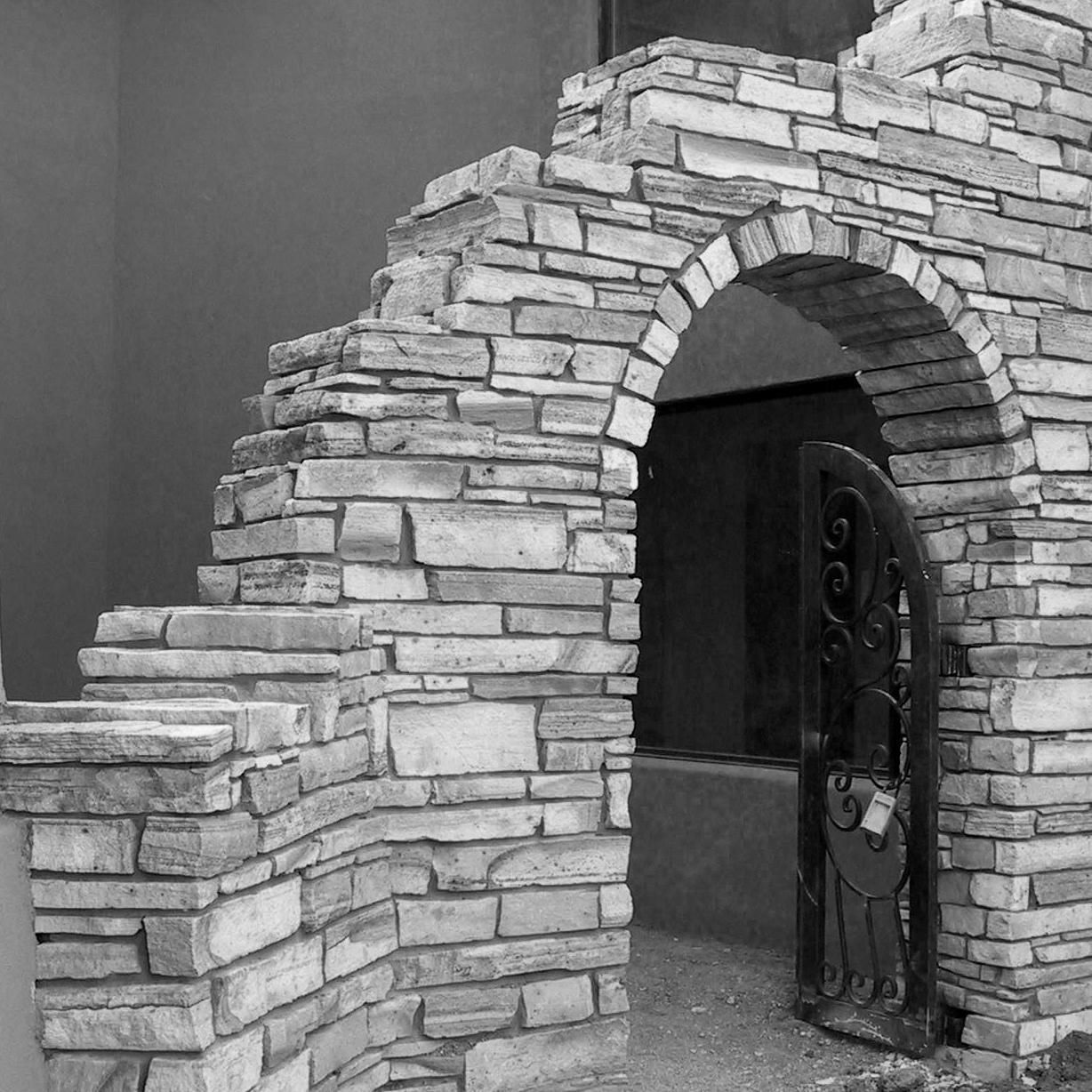 A black and white photo of a stone archway