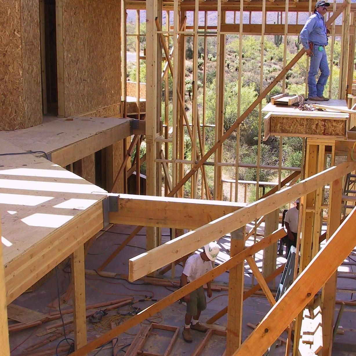 A man is standing on top of a wooden structure