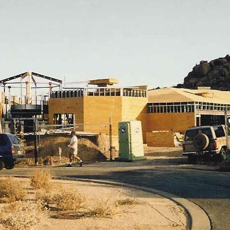 A jeep is parked in front of a building under construction.