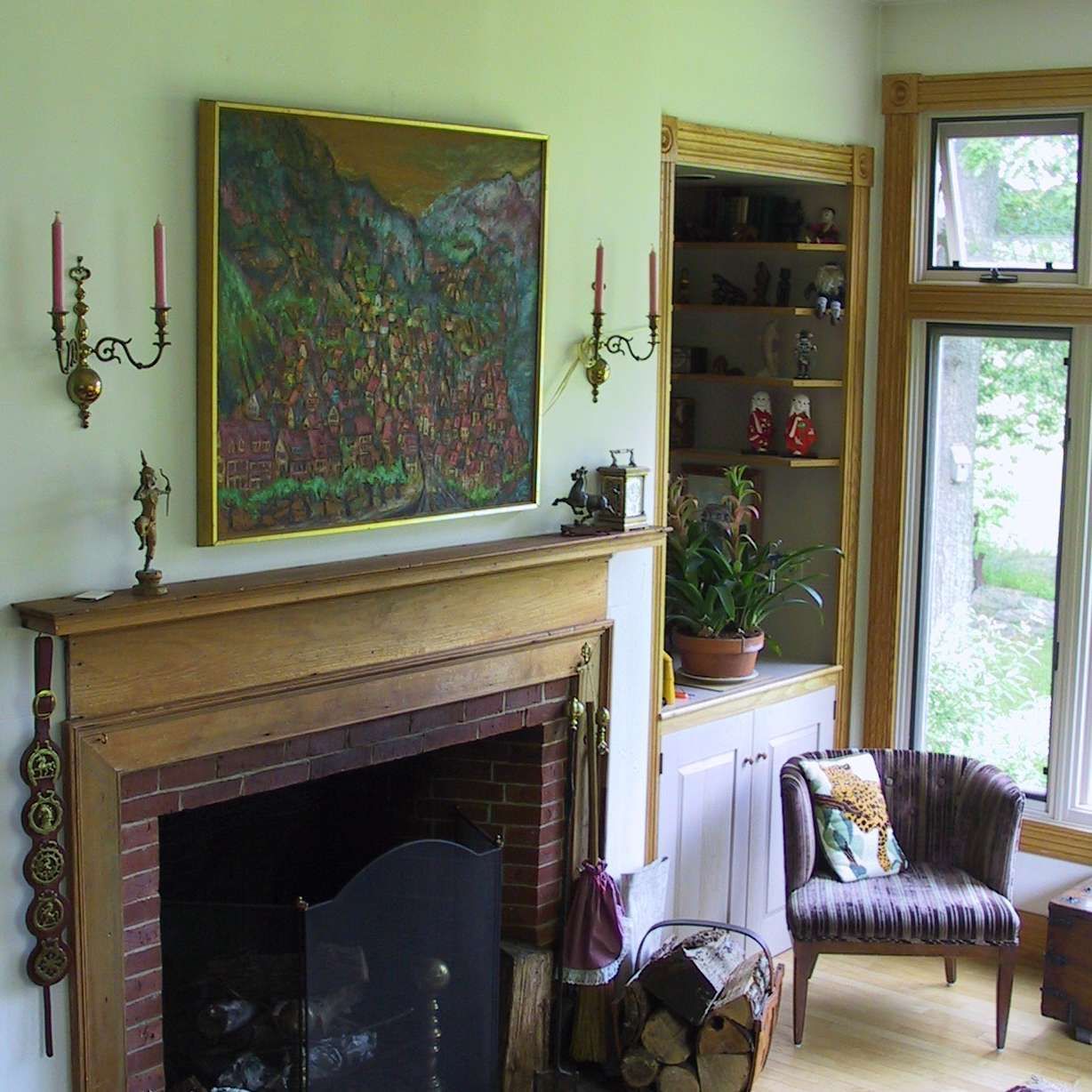 A living room with a fireplace and a painting on the wall