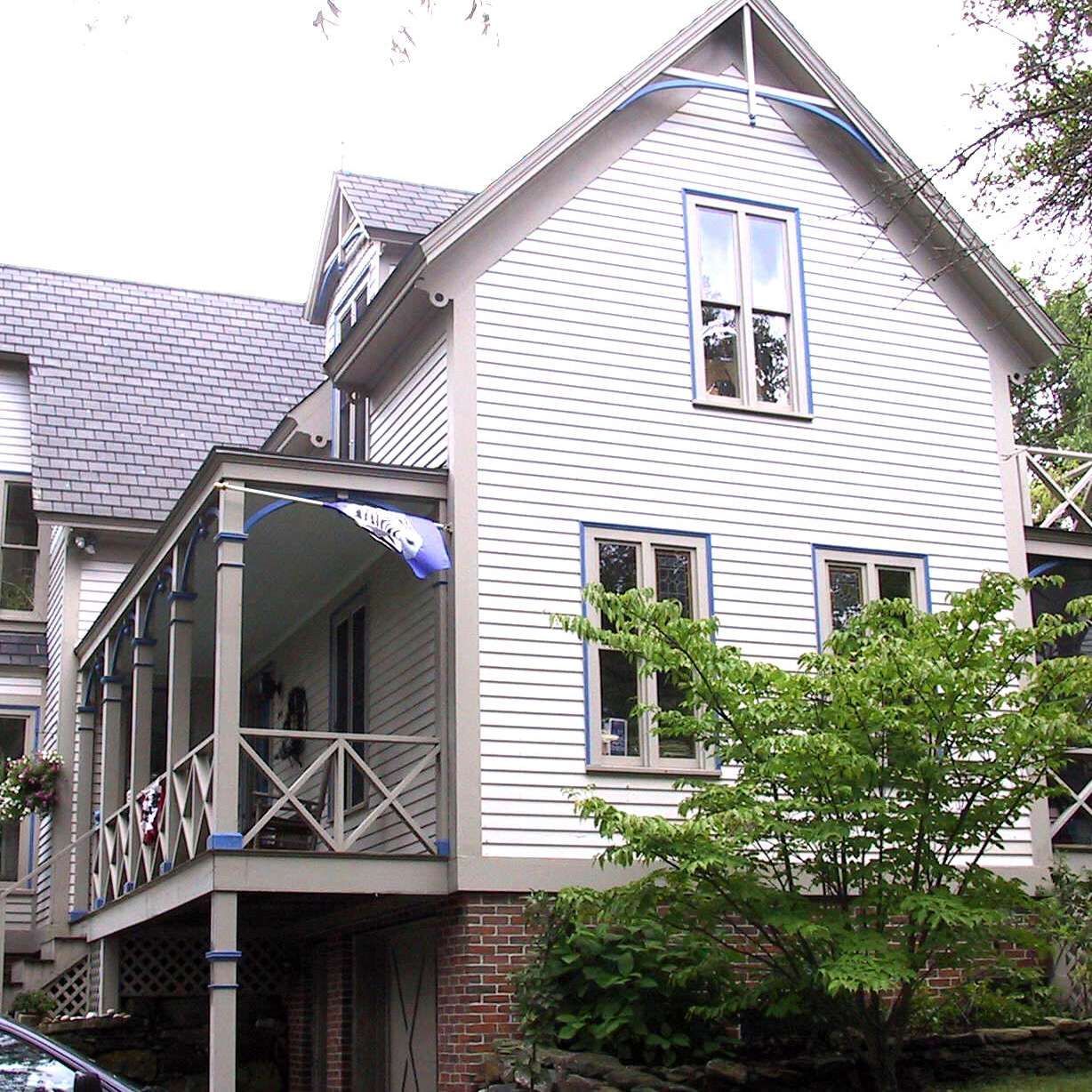 A white house with a blue flag on the porch