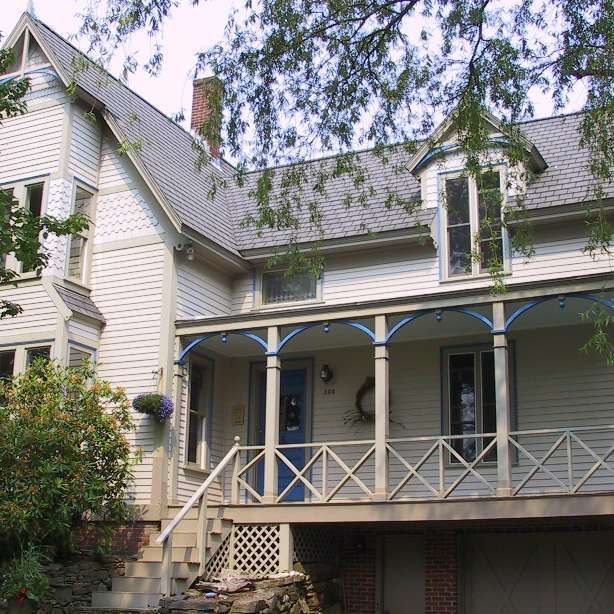 A white house with a blue door and a porch