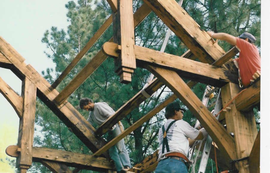 A group of men are working on a wooden structure