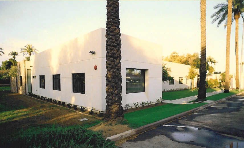 A white building with palm trees in front of it