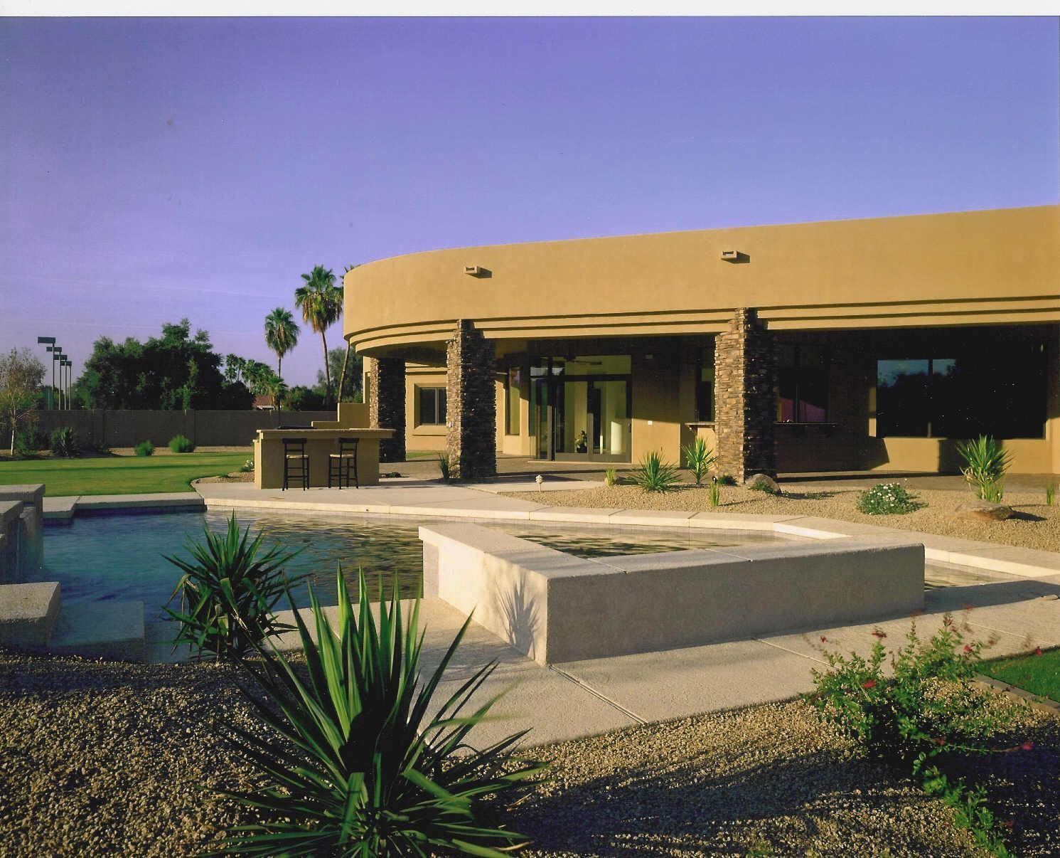A large house with a swimming pool in front of it