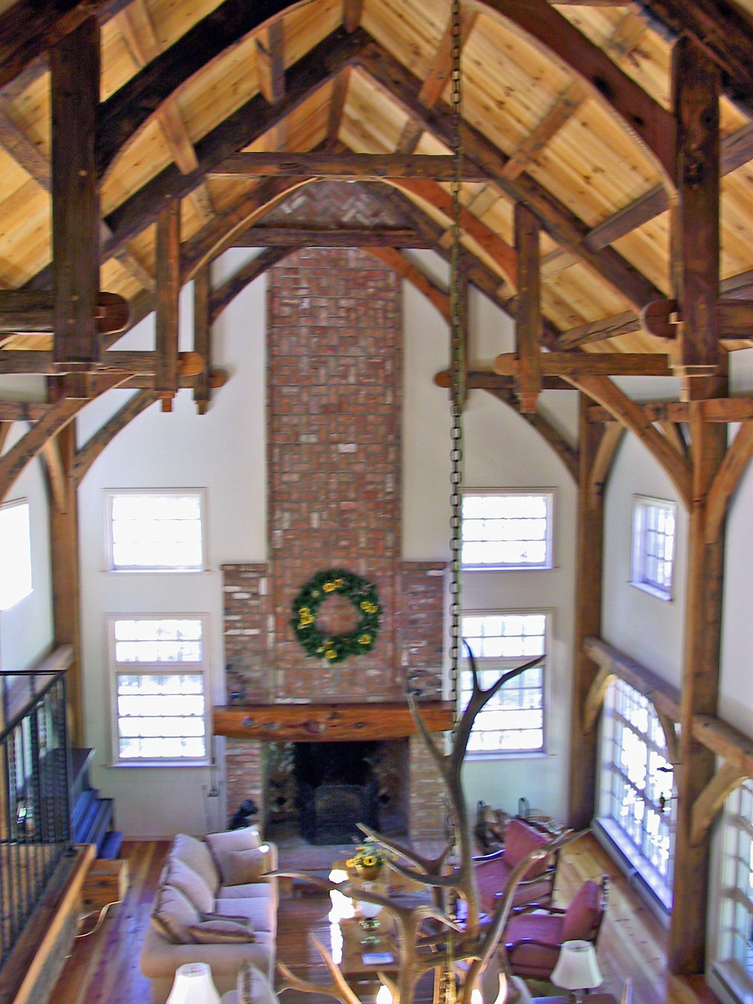 A living room with a brick fireplace and a wreath on it