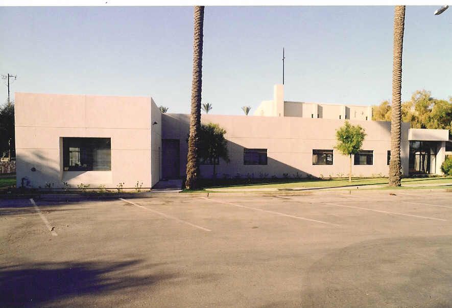 A white building with palm trees in front of it