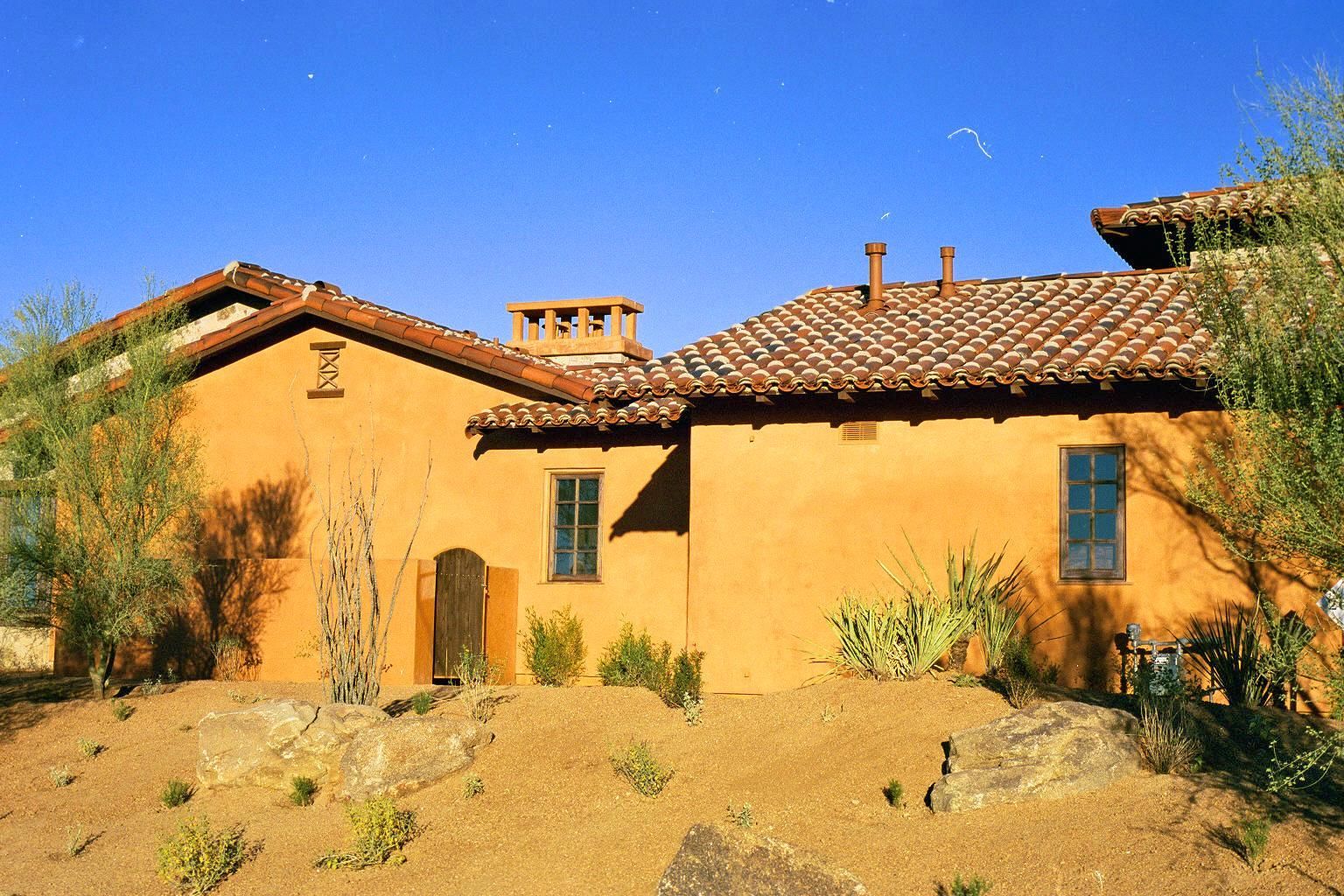 A large house with a tiled roof is in the desert