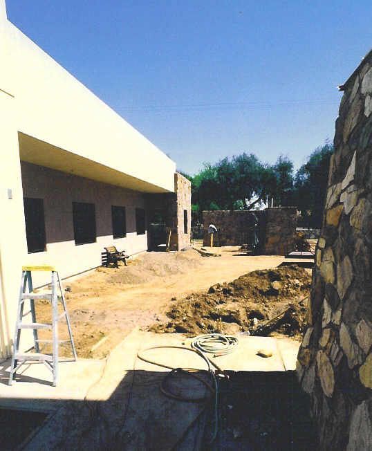 A ladder sits in front of a building under construction