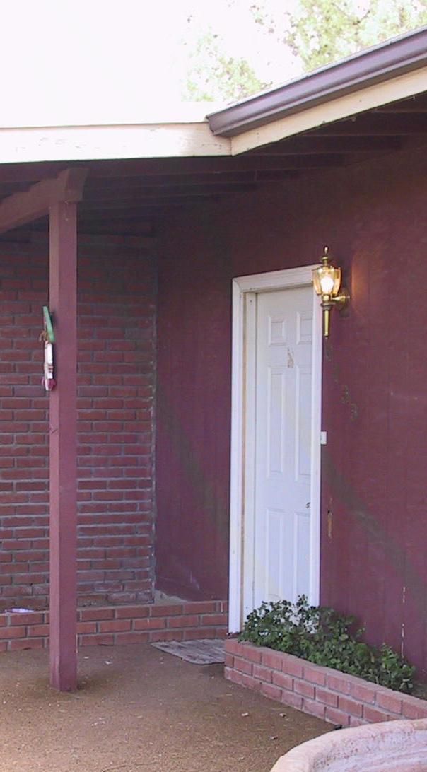 A purple house with a white door and a porch.