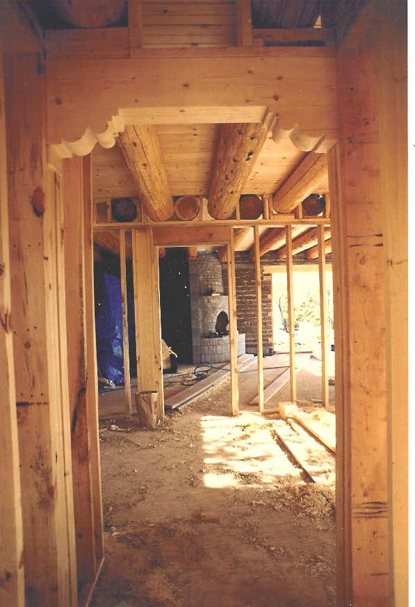 A hallway in a house under construction with a fireplace in the background