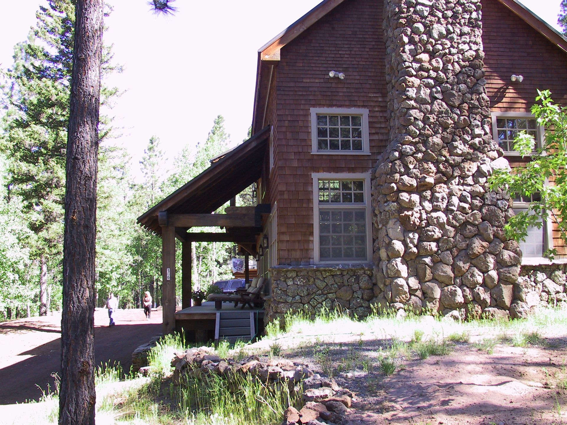 A large stone chimney is on the side of a house