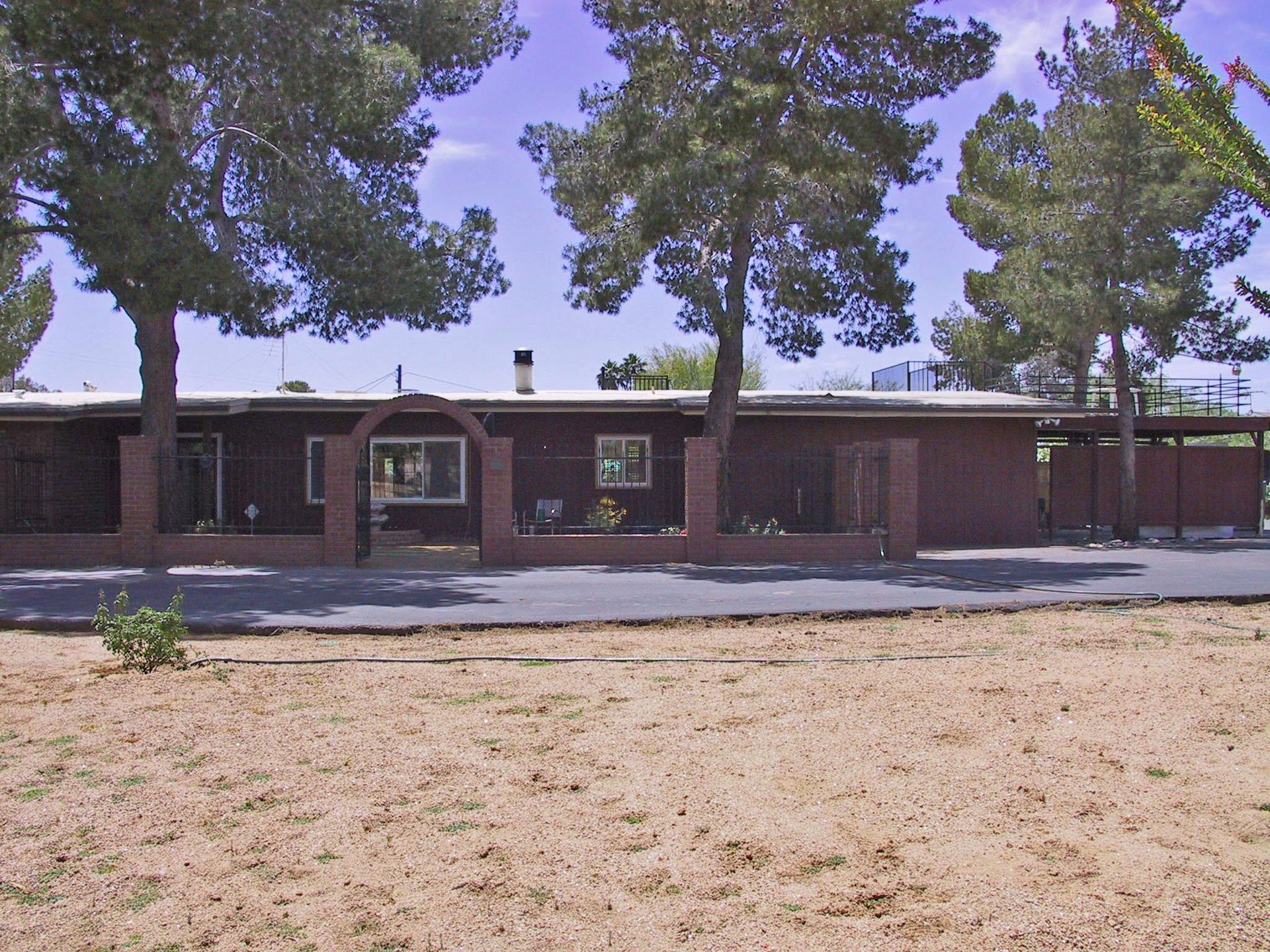 A house with a fence and trees in front of it