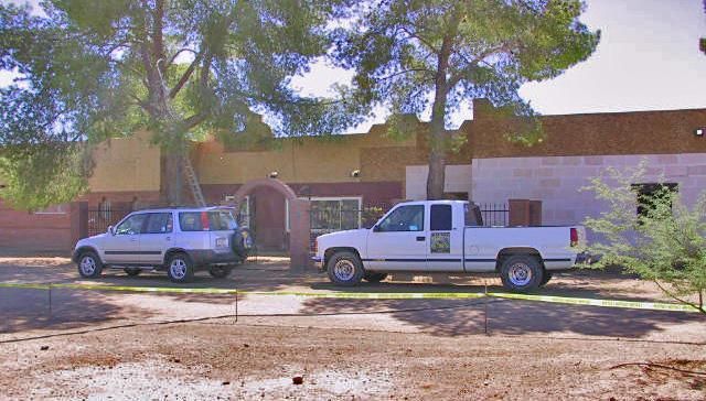 Two white trucks are parked in front of a building