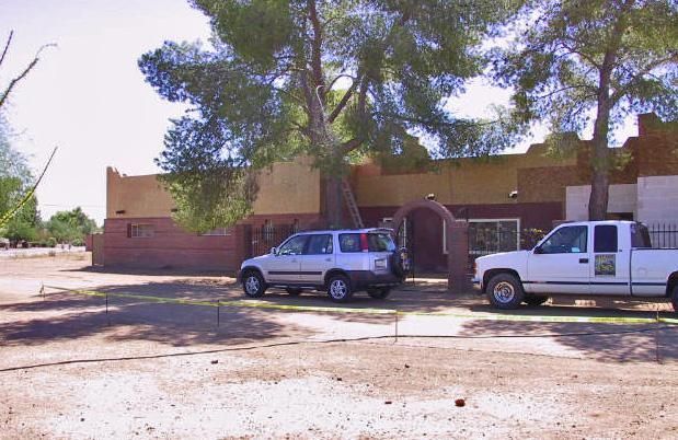 Two white trucks are parked in front of a building
