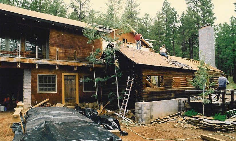 A group of people are working on the roof of a house