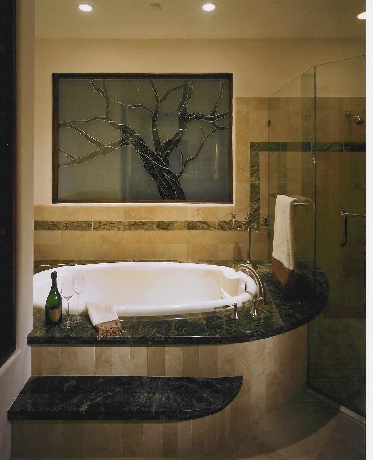 A bathtub in a bathroom with a picture of a tree on the wall