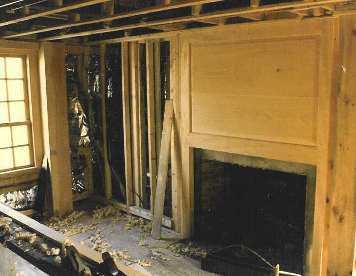 A room under construction with a fireplace in the middle