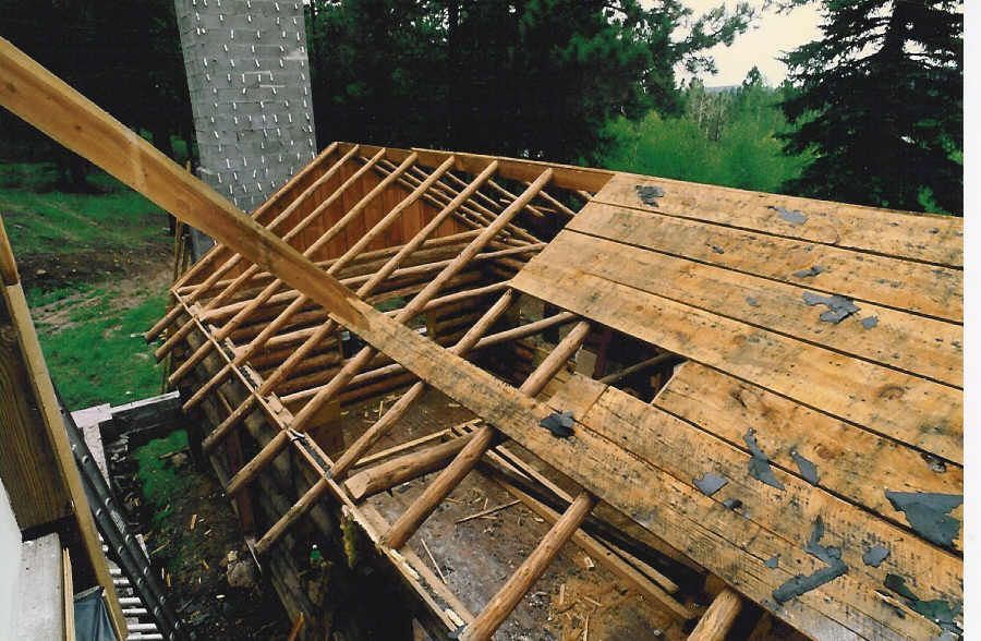 A wooden structure with a chimney in the background