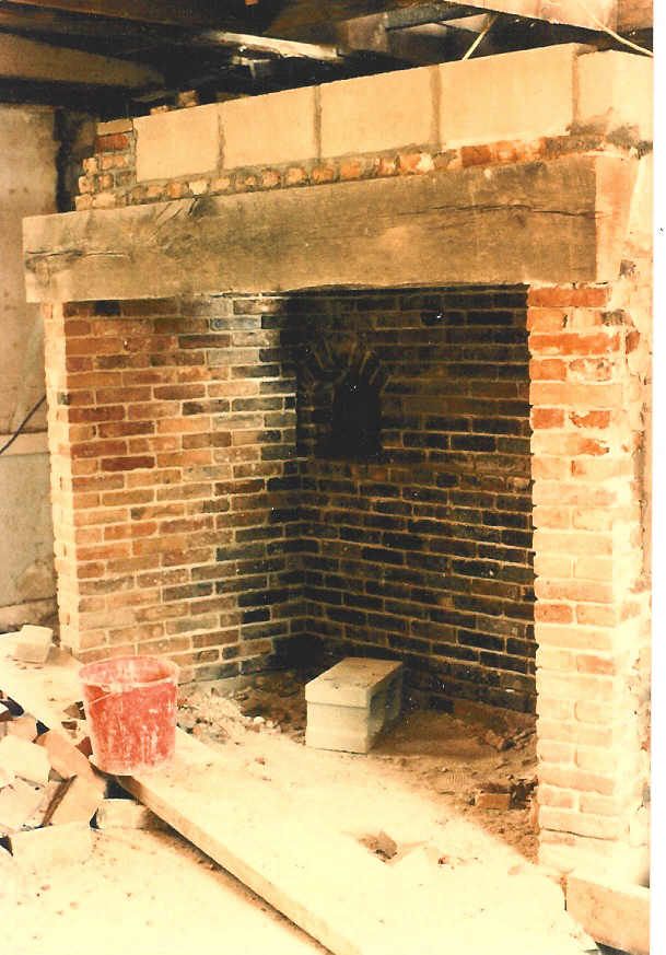 A brick fireplace is being built in a room