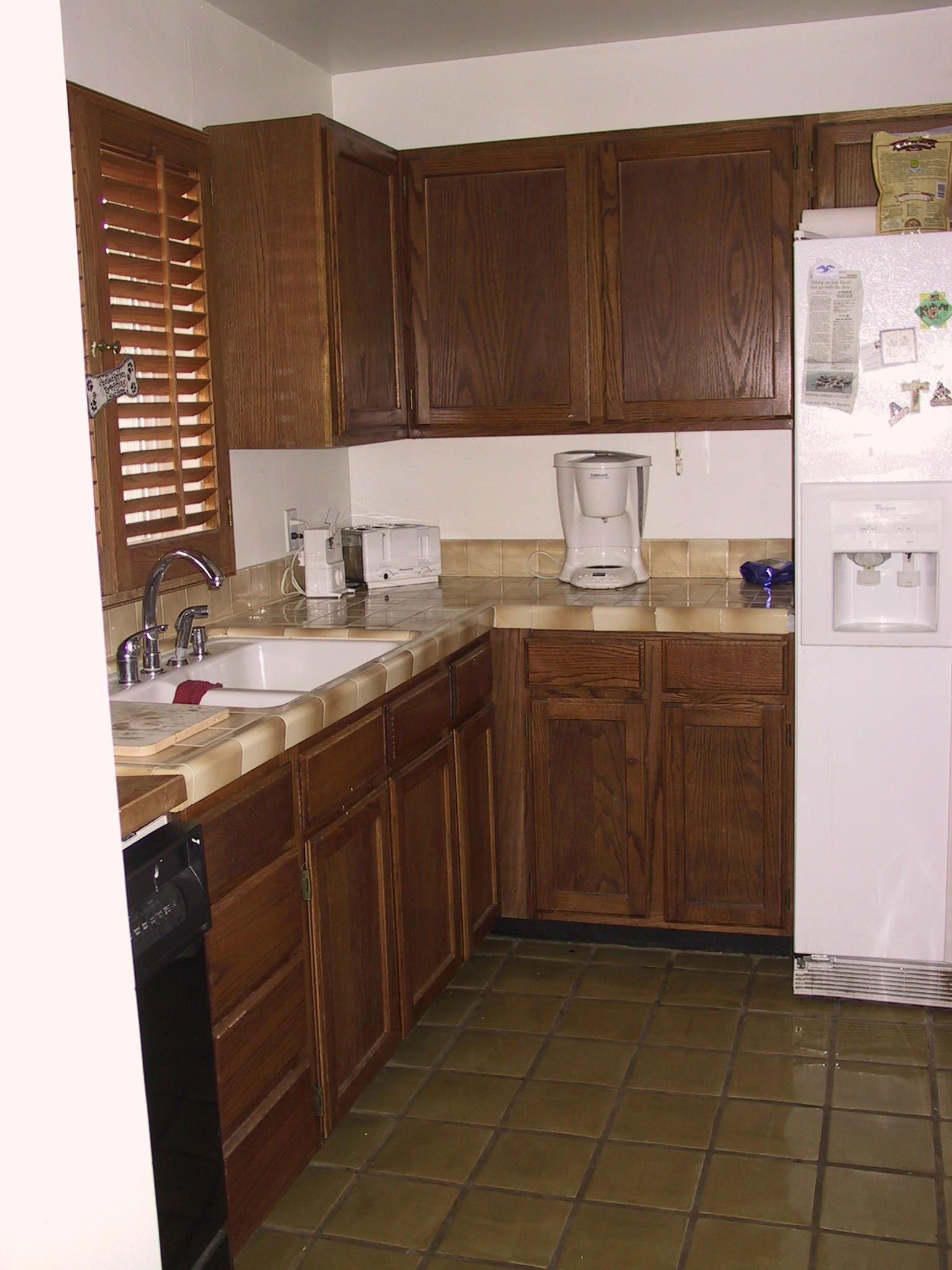 A kitchen with wooden cabinets and a white refrigerator