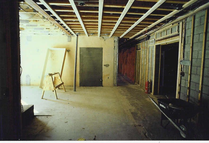 An empty room with a wheelbarrow on the floor