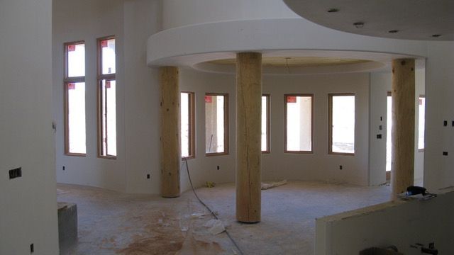 Interior under construction, with columns, windows, and unfinished walls.