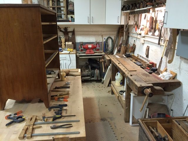 Woodworking workshop with tools and a cabinet in progress.