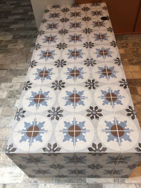 Tiled countertop with a blue, brown, and gray floral pattern.