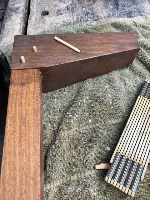 Wooden furniture pieces with dowels, on a towel, wood scraps.